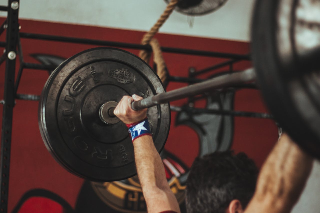 gallery-04 Athlete lifting heavy barbell during strength training session in gym.